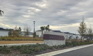 A picturesque entrance with landscaped greenery leading to Hawthorn Park at Wildlight by Pulte Homes in Wildlight, FL.