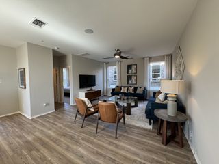 Spacious living room with wood flooring, modern seating, and elegant decor. Bright, airy, and inviting ambiance.