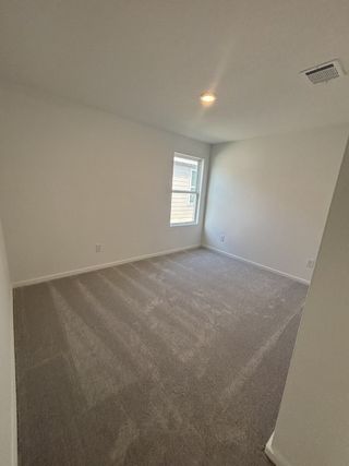 A cozy, carpeted bedroom with soft lighting and a single window, perfect for relaxation and rest.