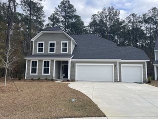 Street view A charming gray two-story home with a spacious three-car garage in Enclave at South Pointe Estates by DRB Homes (Summerville, SC).