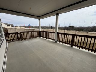 A spacious covered patio with wooden railings, perfect for outdoor relaxation.