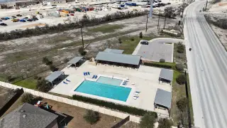 Community Amenities A modern community pool with sun loungers and shaded areas in Hunters Ranch by Chesmar Homes (San Antonio, TX).