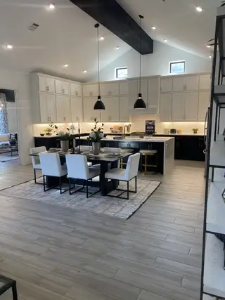 A luxurious kitchen with vaulted ceilings, striking black pendant lights, and a spacious dining area designed for entertaining.