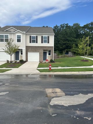 A charming two-story townhouse with a manicured lawn in Glenn Crossing by Starlight Homes (Durham, NC).