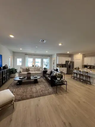 A spacious open-concept living area featuring cozy seating, elegant décor, and a modern kitchen with island seating.