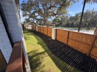 A beautifully landscaped yard with a warm wooden fence and lush greenery.