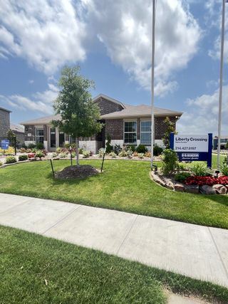 A beautiful brick home with lush landscaping at Liberty Crossing by D.R. Horton in Royse City, TX.
