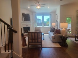 A cozy living room with a fireplace, plush seating, and natural light from large windows, offering a warm and inviting atmosphere.