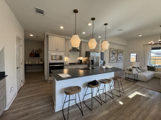 Model Home A gourmet kitchen featuring stainless steel appliances, a subway tile backsplash, and ample counter space.