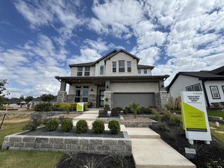 A modern two-story brick home with landscaped yard in Patterson Ranch by Pulte Homes (Georgetown, TX).