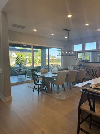 A modern dining area with elegant seating, a large window view, and stylish lighting, offering a cozy ambiance.