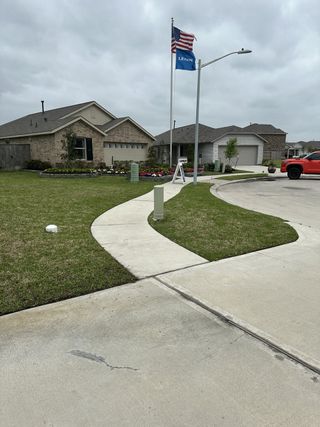 Street view A charming brick home with landscaped yard, located in Tavola by Lennar (New Caney, TX).