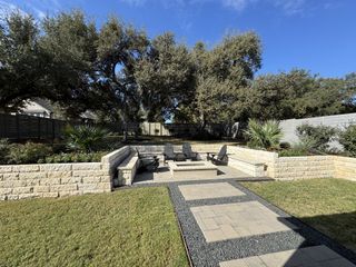 Model Home A beautifully landscaped backyard patio with cozy seating and lush greenery.