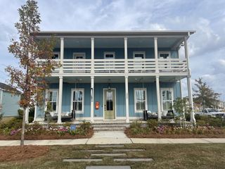 Street view A charming blue home with double porches and lush landscaping in The Domus Collection at Midtown Nexton by New Leaf Builders (Summerville, SC).