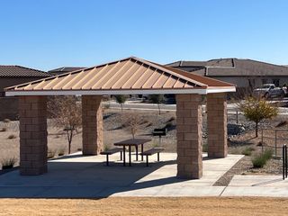 A charming pavilion with stone pillars and a metal roof in Forté at Granite Vista by Elliott Homes (Waddell, AZ).