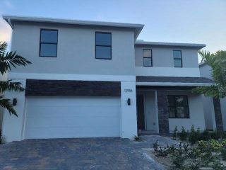 Modern two-story home with sleek lines and a stone accent in Rosemont by D.R. Horton (Miami, FL).