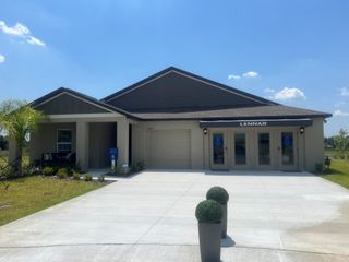 A modern model home with a spacious driveway in Prosperity Lakes by Lennar (Parrish, FL).