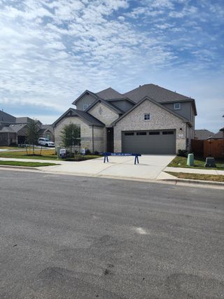 A beautiful brick home with a spacious driveway in Rosenbusch Ranch by D.R. Horton (Leander, TX).