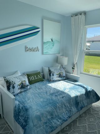 A beach-themed bedroom with coastal decor, a surfboard, and relaxing accents, perfect for a tranquil retreat.