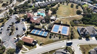 Community Amenities A stunning aerial perspective of Travisso, highlighting tennis courts, recreational spaces, and elegant homes (Leander, TX).