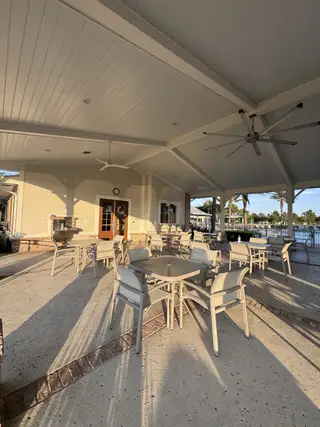 A spacious outdoor pavilion with comfortable seating and ceiling fans, perfect for gatherings and relaxation.