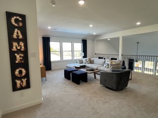 A cozy, spacious living area with plush seating, modern accents, and ample natural light through large windows.