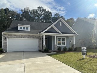 A charming gray brick home with a spacious garage in Parker's Preserve by Eastwood Homes (Ridgeville, SC).