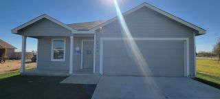 Street view A charming grey home with a welcoming porch and garage in Legacy Point: Watermill Collection by Lennar (Von Ormy, TX).