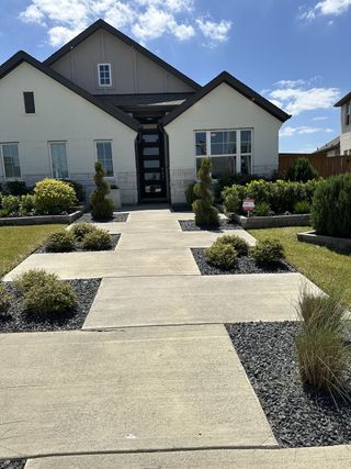 Street view A charming modern home with neat landscaping in Cypress Green by Brightland Homes (Hockley, TX).