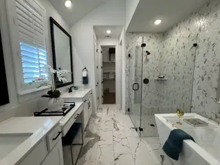 Elegant bathroom with green tiled shower, black fixtures, and a modern vanity.