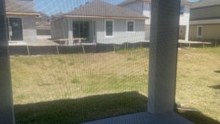 A scenic backyard view from a covered patio in Reunion Village by LGI Homes (Kissimmee, FL).