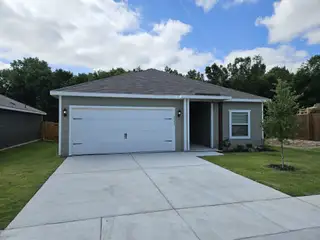 Street view A modern gray home with a spacious driveway and greenery in College Park by LGI Homes (Dallas, TX).