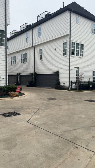 Stylish white townhomes with black garage doors in Timbergrove Green by InTown Homes, Houston, TX.