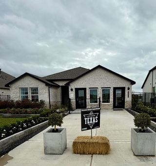 A charming brick home with modern windows and landscaped yard in Lago Mar by D.R. Horton (Texas City, TX).