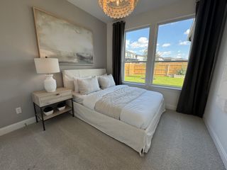 Model Home A serene guest bedroom with soft neutrals, a plush white bed, large windows, and a stunning abstract art piece.