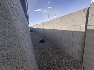 Street view A side view of a gravel pathway along a stucco wall in Agave Trails by Starlight Homes, Buckeye, AZ.