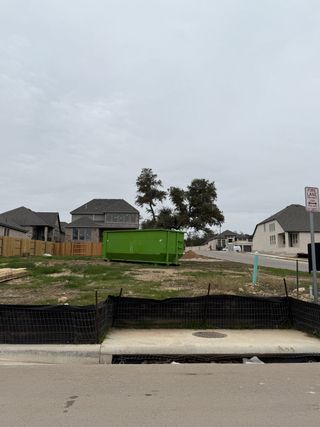 Construction-ready lot in Parkside Peninsula by Highland Homes, Georgetown, TX, with surrounding homes and greenery.