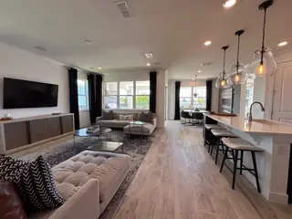 A spacious living room with elegant seating, large windows, and contemporary light fixtures