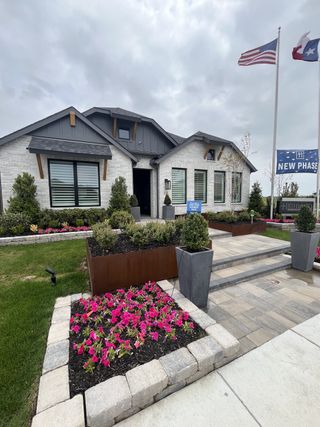 A chic white brick home with elegant landscaping in Waterscape: 50ft. lots by Highland Homes (Royse City, TX).