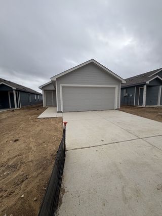 A newly built home with a two-car garage, gray siding, and a clean driveway in Sapphire Grove by Lennar (San Antonio, TX).
