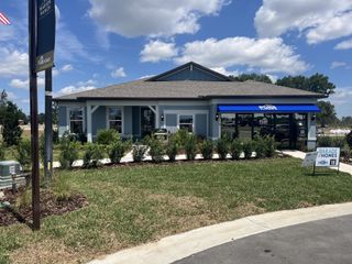 Street view A charming blue home with landscaped front yard in Marion Ranch by Pulte Homes (Ocala, FL).