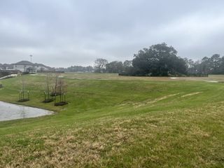 Expansive green space with serene pond views in Champions Oak by Long Lake Ltd. (Houston, TX).