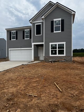 Charming gray two-story home with black shutters in Casteel by Starlight Homes, Bethlehem, GA.