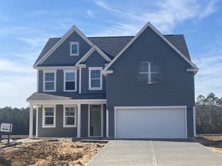 A modern gray two-story home with white trim and a spacious driveway in Berkeley Bay by D.R. Horton (Ridgeville, SC).