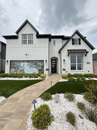 A stunning white brick home with landscaped garden in the Venetian community by Megatel Homes (Celina, TX).