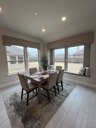  Beautiful dining room with a wooden table, stylish chairs, large windows, and soft lighting for a cozy ambiance.