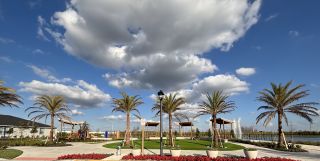 Community Amenities A picturesque park with palm trees and vibrant landscaping in EverBe: Cottage Alley Collection by Lennar (Orlando, FL).