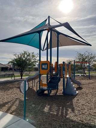 Community Amenities A vibrant playground with shaded structures in Village at Sundance by Centex, Buckeye, AZ.
