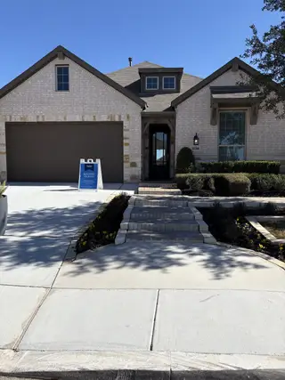 A charming stone home with a manicured lawn in Davis Ranch: 50ft. lots by Highland Homes (San Antonio, TX).