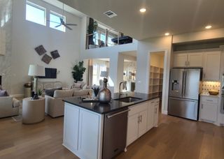 A modern open-concept living room with high ceilings, sleek kitchen island, and ample natural light.